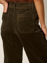 Load image into Gallery viewer, Close-up back view of a woman wearing dark brown corduroy pants, showing the waistband, belt loops, and back pockets against a plain light background.